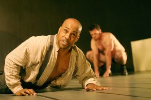 Man on his stomach - unclothed man in the background